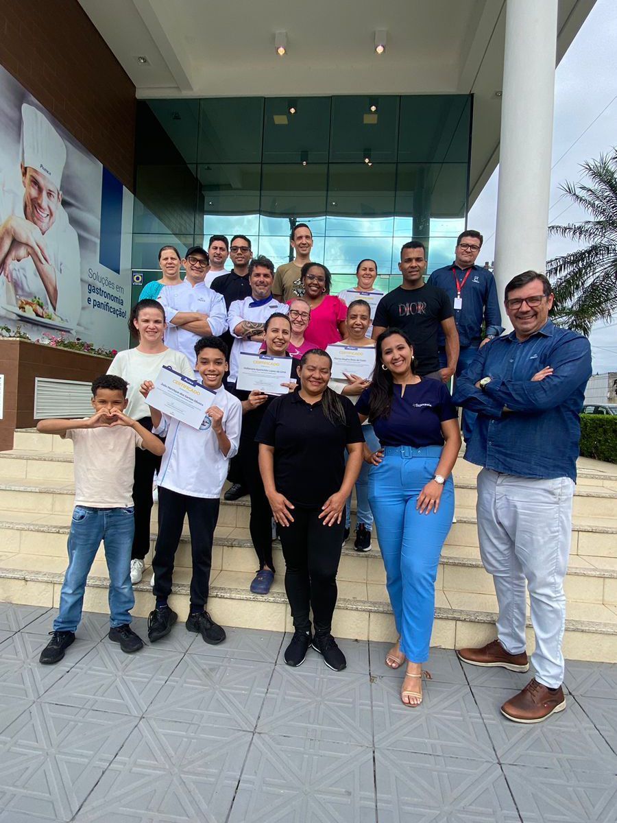 Um grupo de pessoas está posando para uma foto em frente a um prédio.