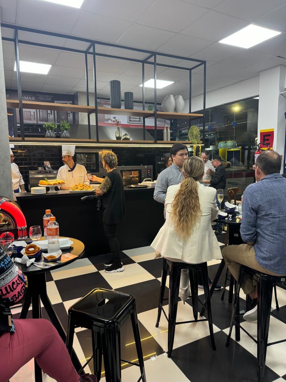 Um grupo de pessoas está sentado em mesas em um restaurante.