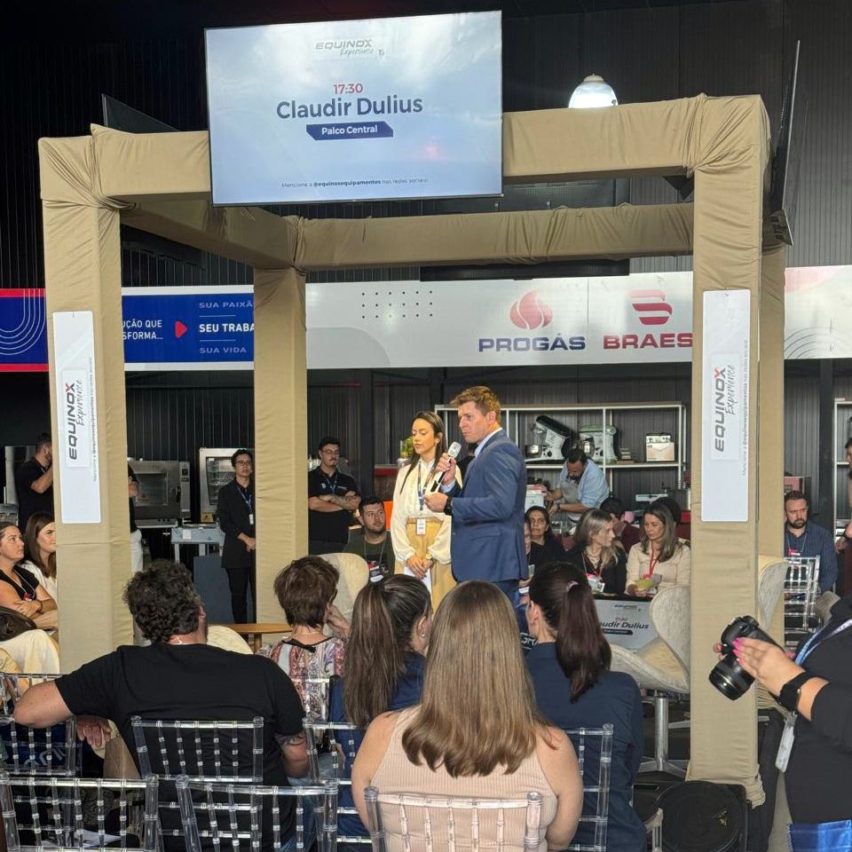 Um grupo de pessoas está sentado sob uma placa que diz claudir dulius