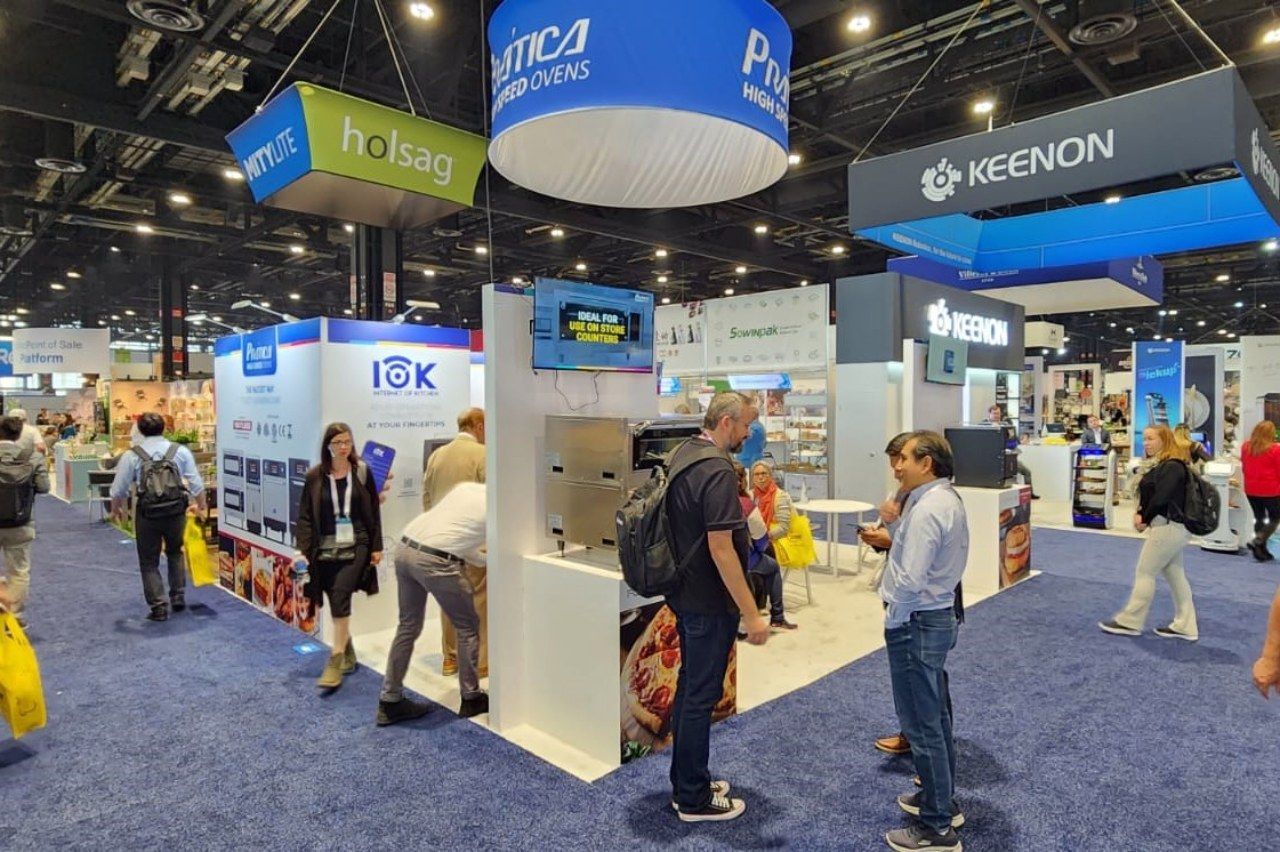 Um grupo de pessoas está em volta de um estande em uma convenção.