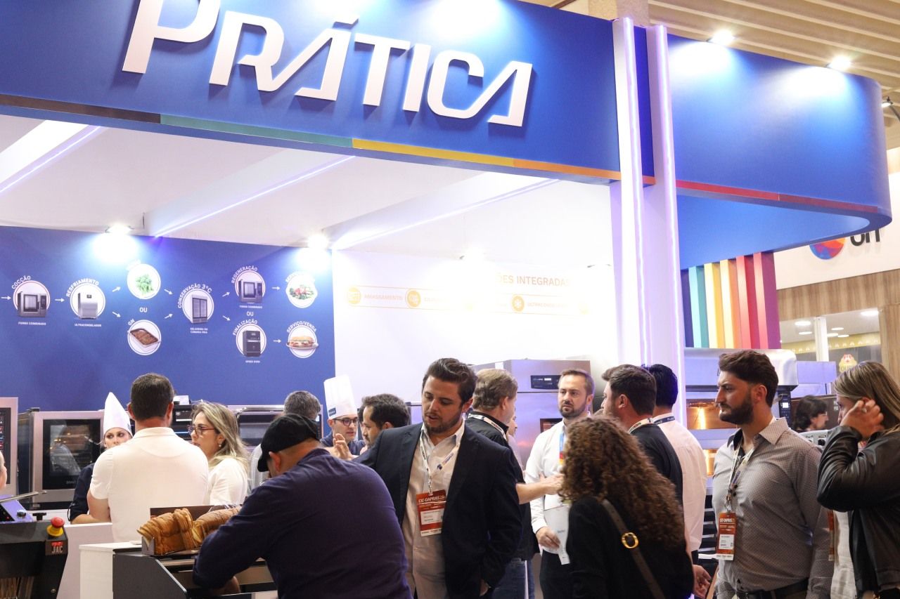 Um grupo de pessoas está em frente a uma placa de prática.