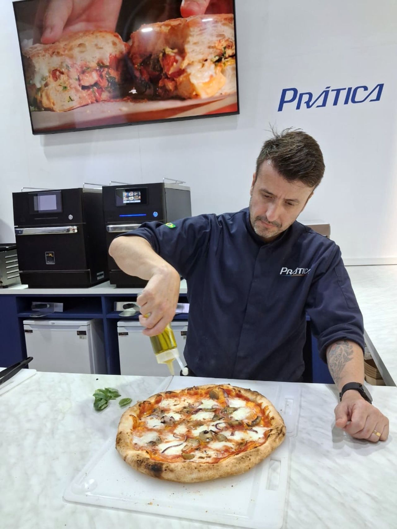 Chef derramando óleo sobre uma pizza. Cozinha comercial, logotipo 
