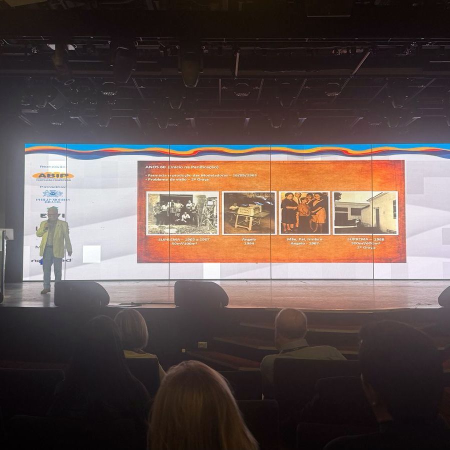 Um grupo de pessoas está sentado em frente a uma tela grande.