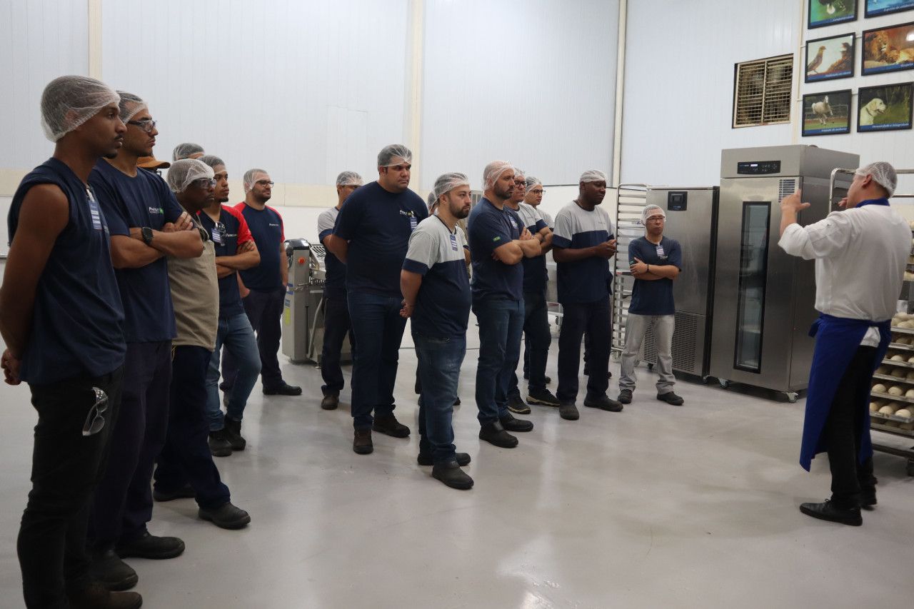 Um grupo de homens está em uma sala com um homem conversando com eles.
