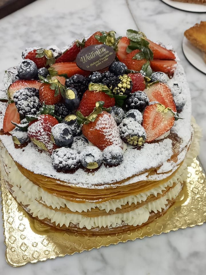 Um bolo com morangos, mirtilos e chantilly por cima