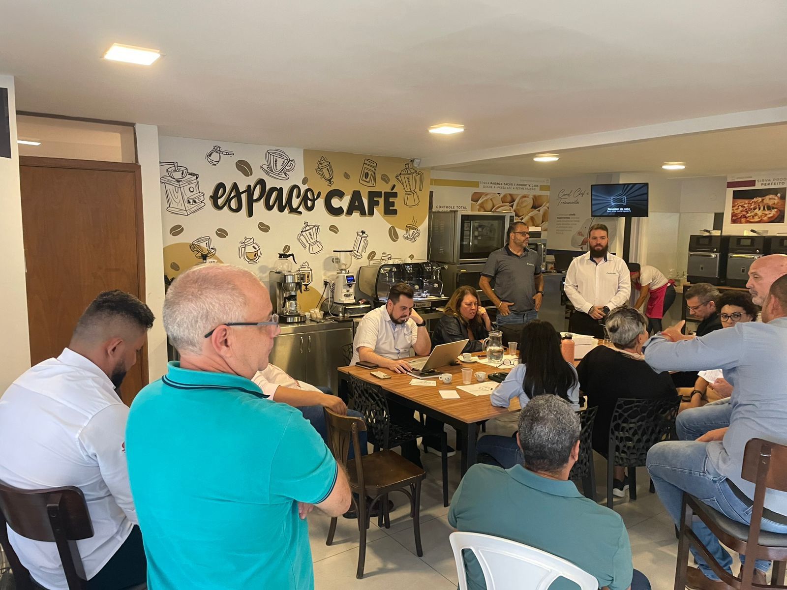 Um grupo de pessoas está sentado em mesas em um café.
