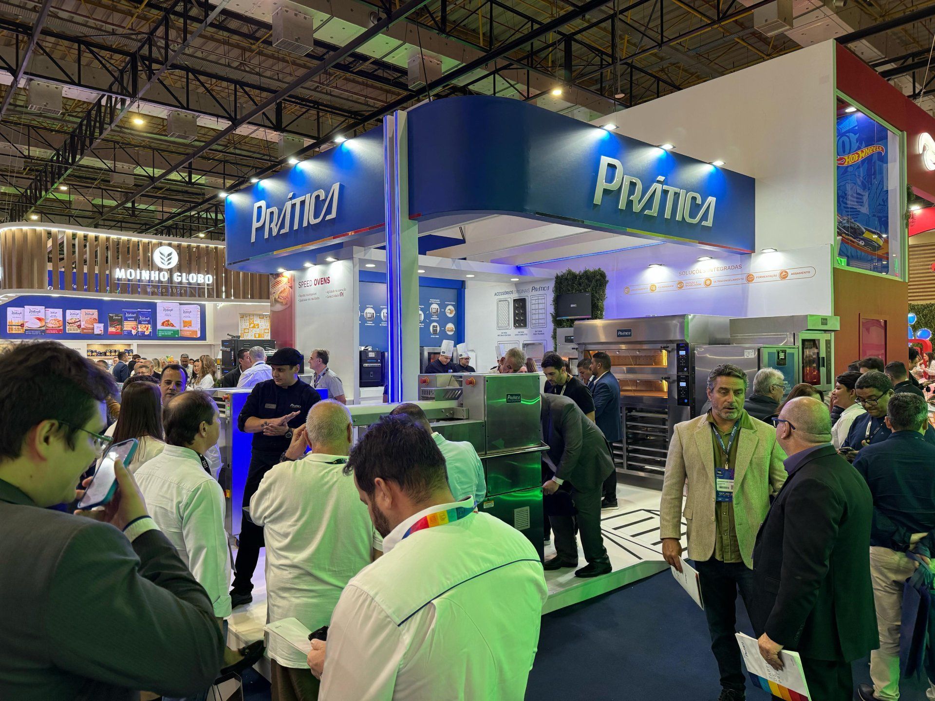 Um grupo de pessoas está em volta de um estande em uma convenção.