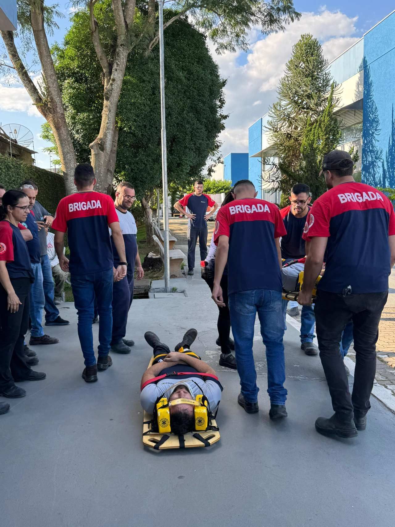 Um grupo de pessoas está em pé ao redor de uma pessoa deitada em uma maca.