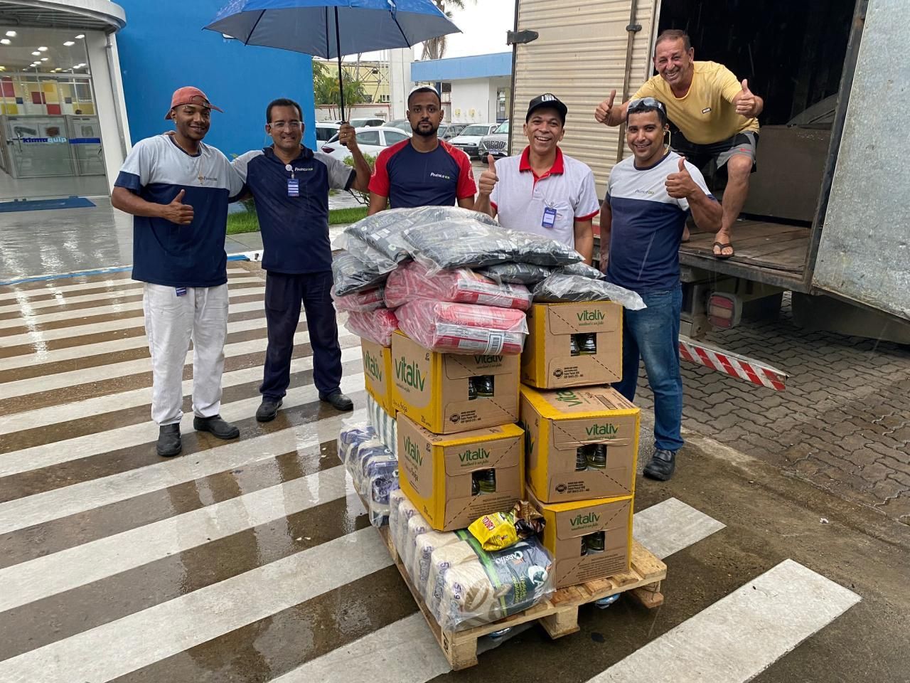 Um grupo de homens está em frente a um caminhão com caixas.