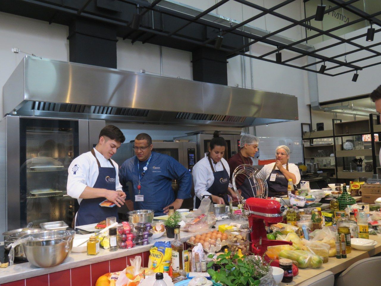 Um grupo de pessoas está em uma cozinha preparando comida.