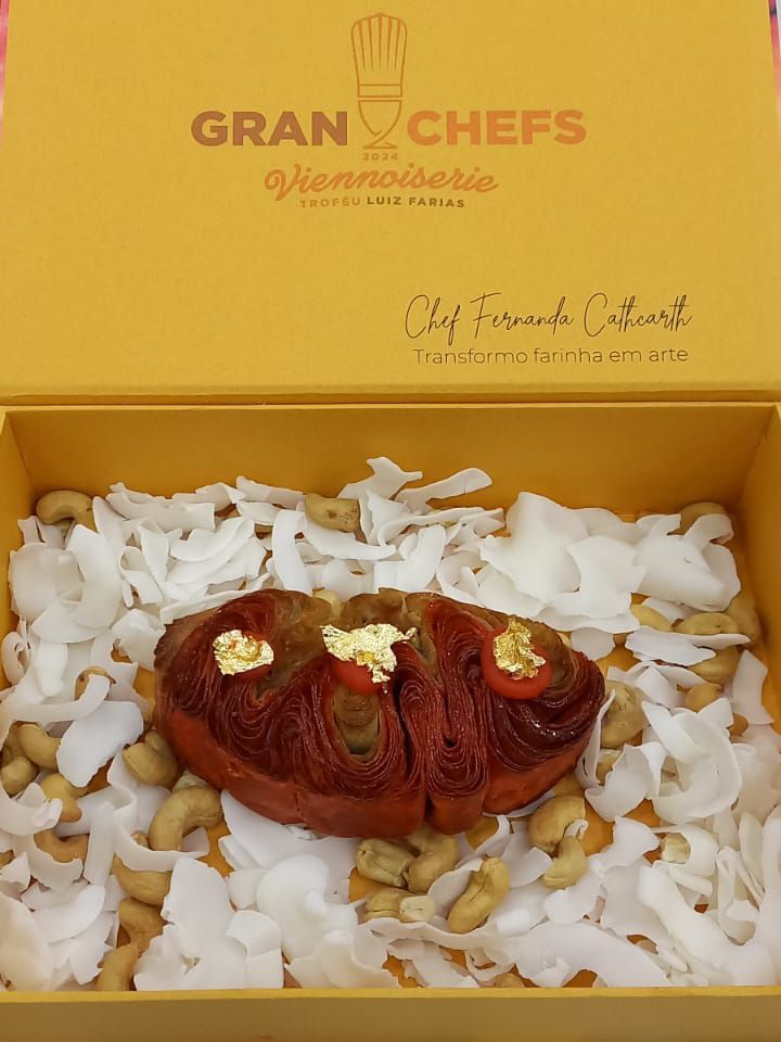 Uma caixa amarela cheia de nozes e um pedaço de comida.