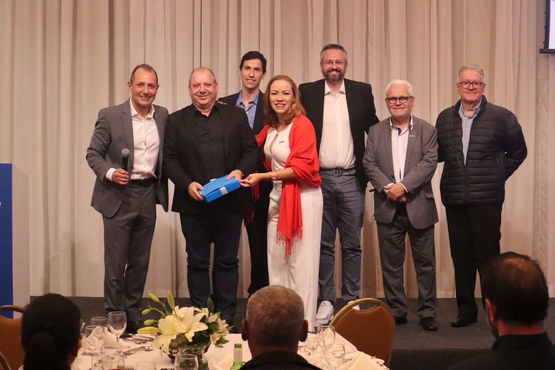 Um grupo de pessoas está posando para uma foto em uma conferência.