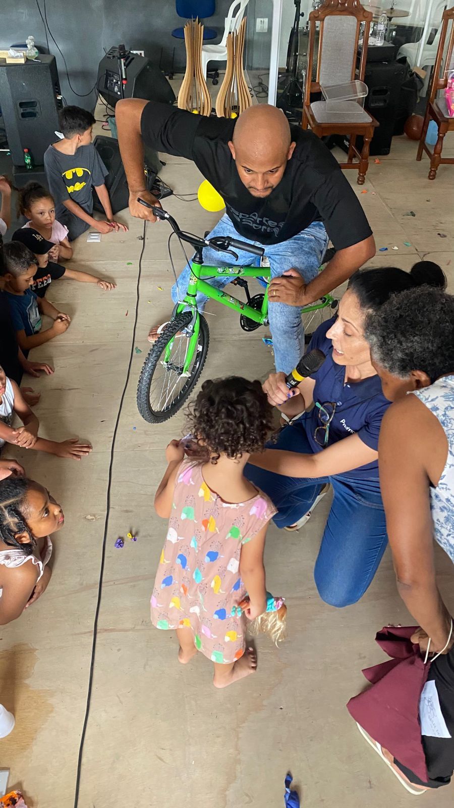 Um grupo de pessoas está sentado ao redor de uma bicicleta verde.