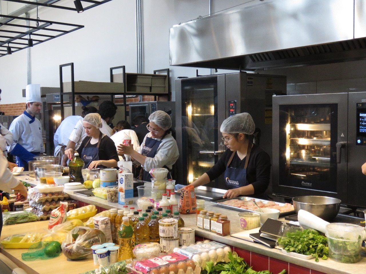 Um grupo de pessoas está preparando comida em uma cozinha