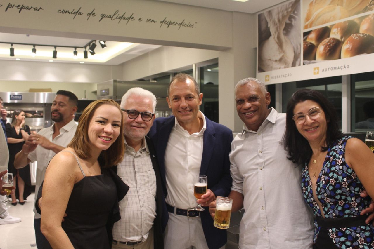 Um grupo de pessoas posa para uma foto segurando copos de cerveja.