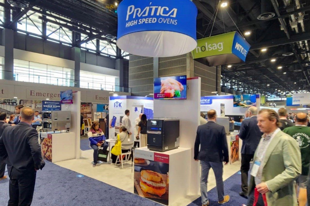 Um grupo de pessoas está em volta de um estande em uma convenção.