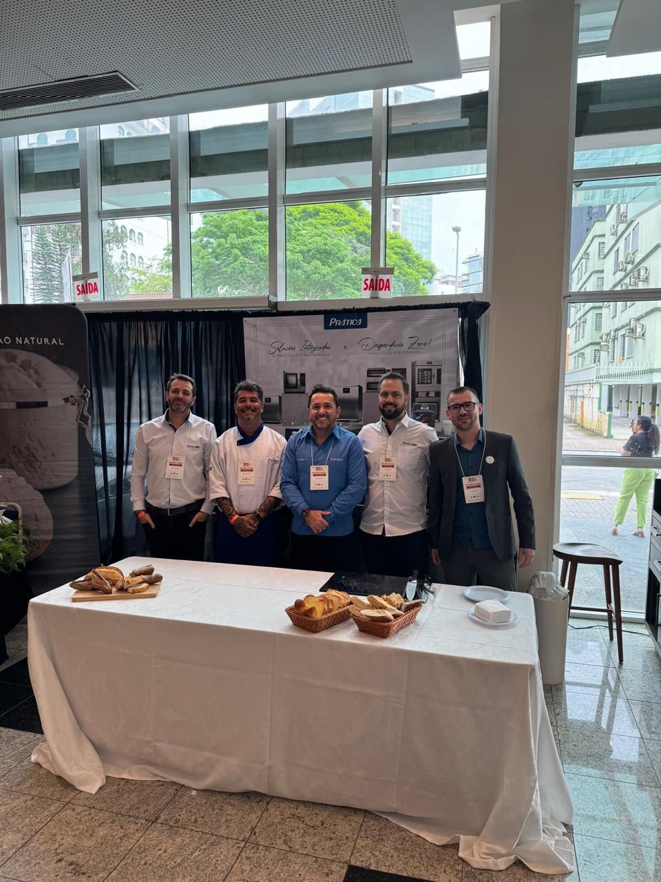 Um grupo de homens está posando para uma foto em frente a uma mesa.