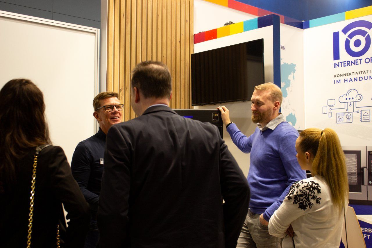 Um grupo de pessoas está em uma sala conversando entre si.