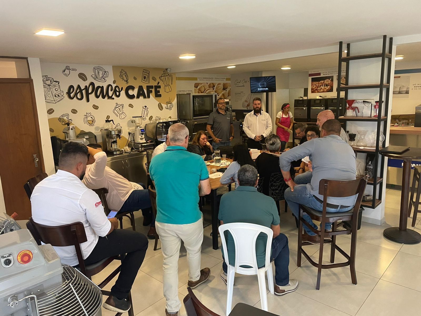 Um grupo de pessoas está sentado em mesas em um café.