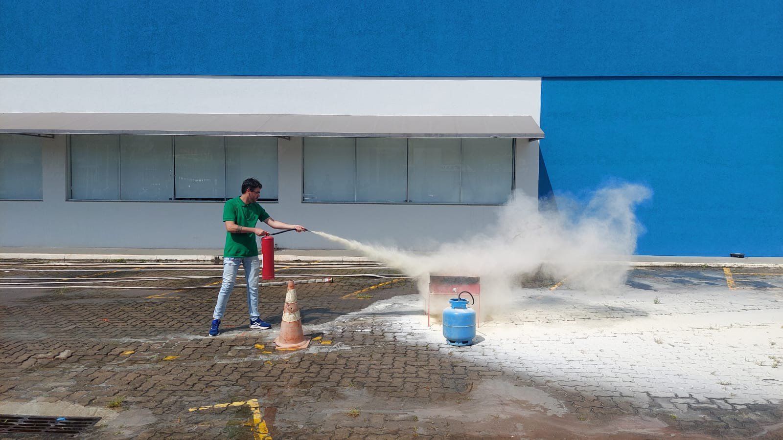 Um homem está usando um extintor de incêndio para apagar um incêndio.