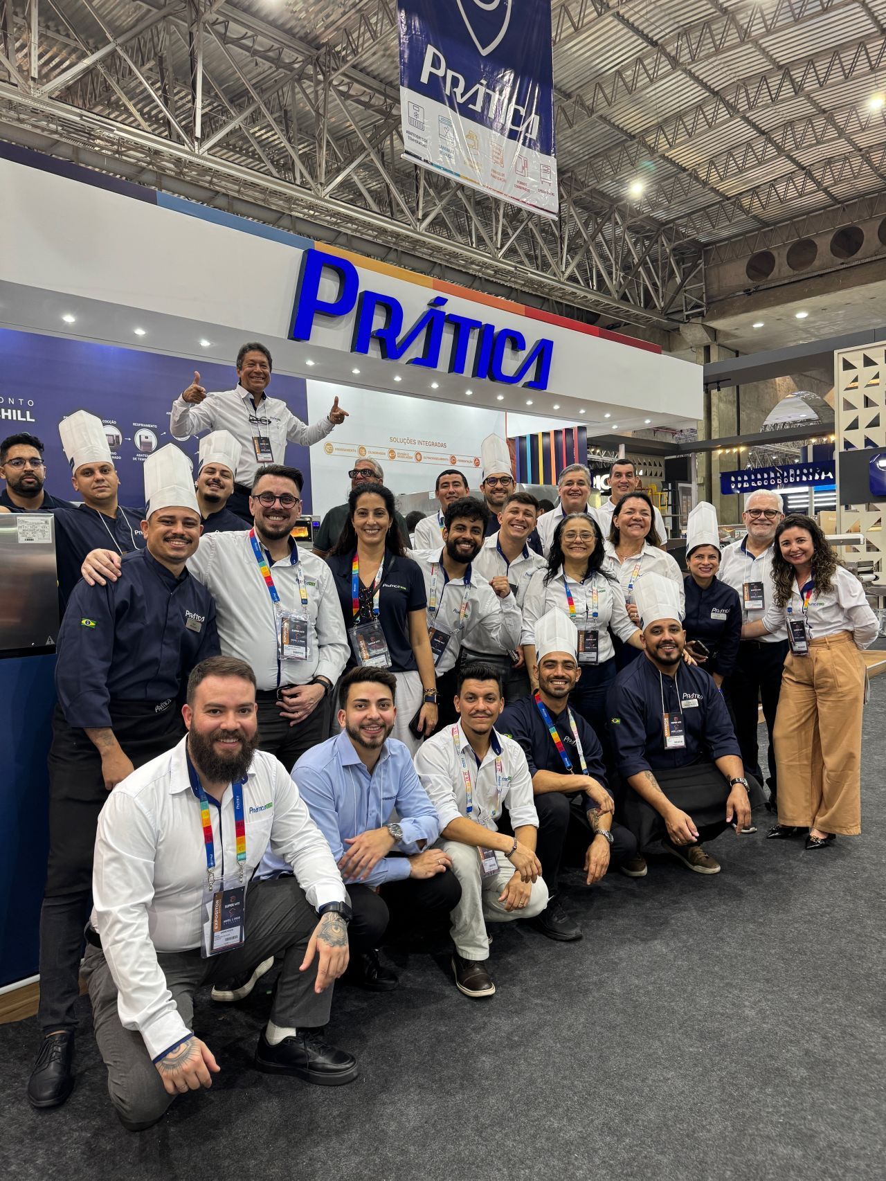 Grupo de pessoas posando em frente à placa 