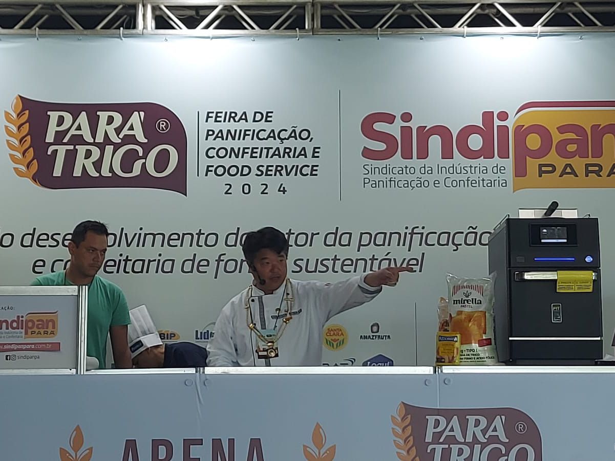 Um grupo de pessoas em pé em frente a uma placa que diz para trigo