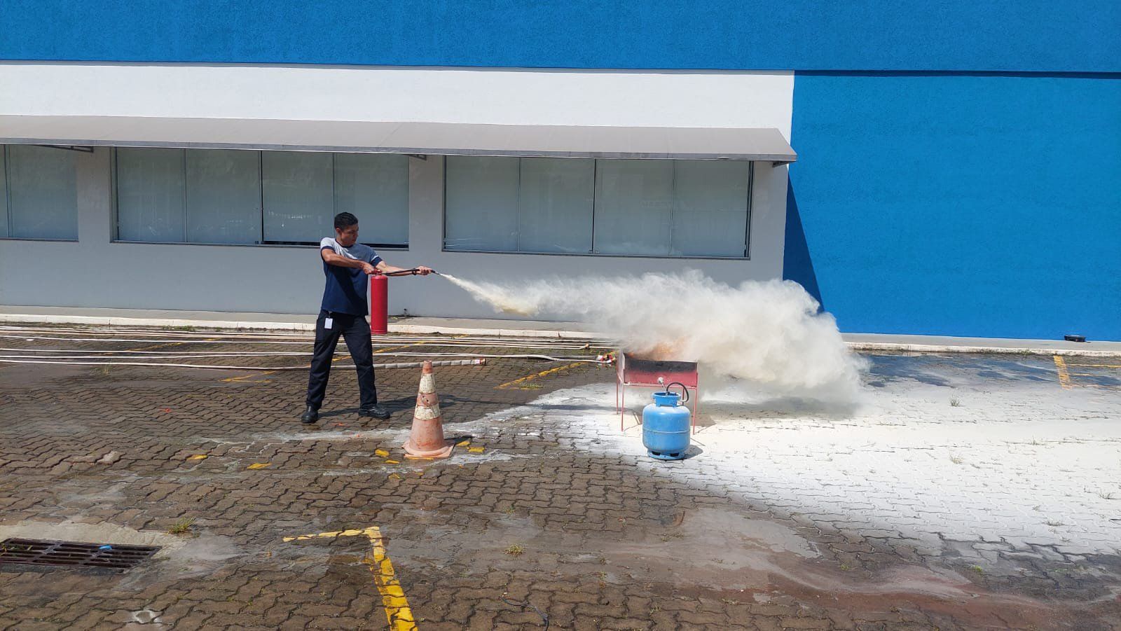 Um homem está usando um extintor de incêndio para apagar um incêndio