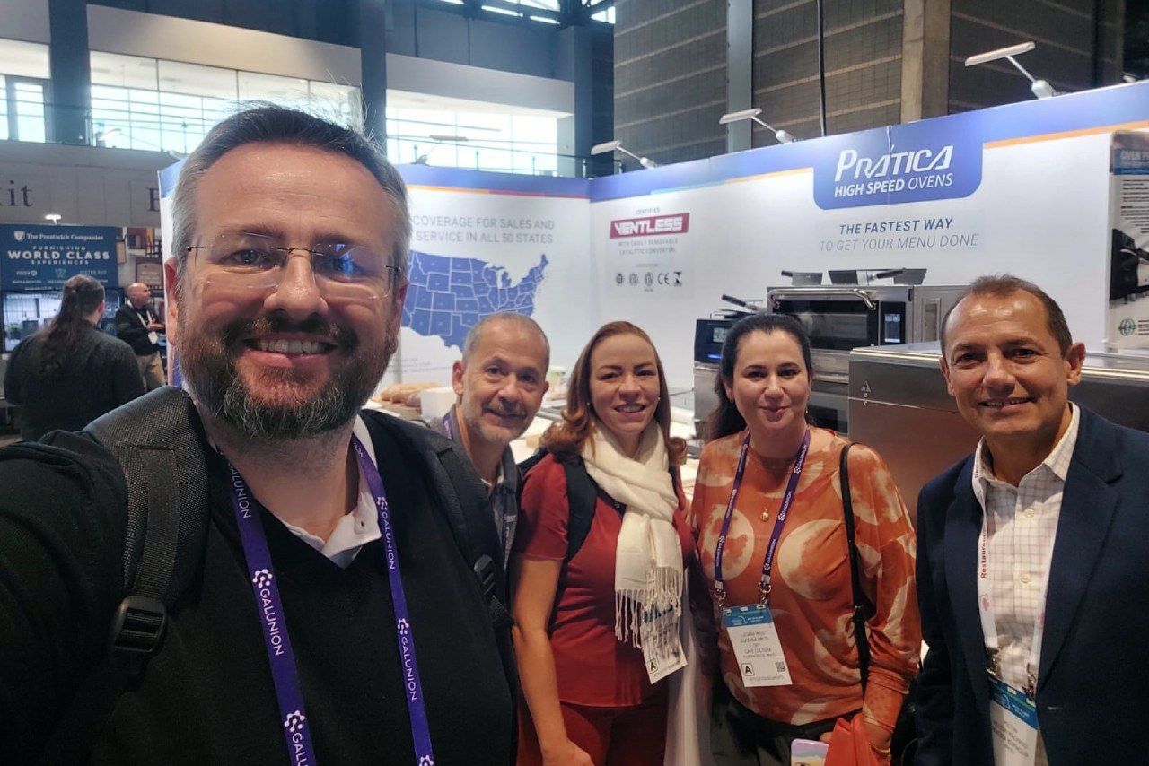 Um grupo de pessoas está posando para uma foto em uma convenção.