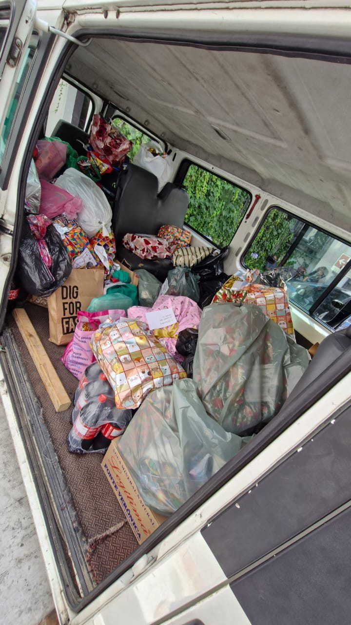 A parte de trás de uma van está cheia de muitas sacolas e caixas.