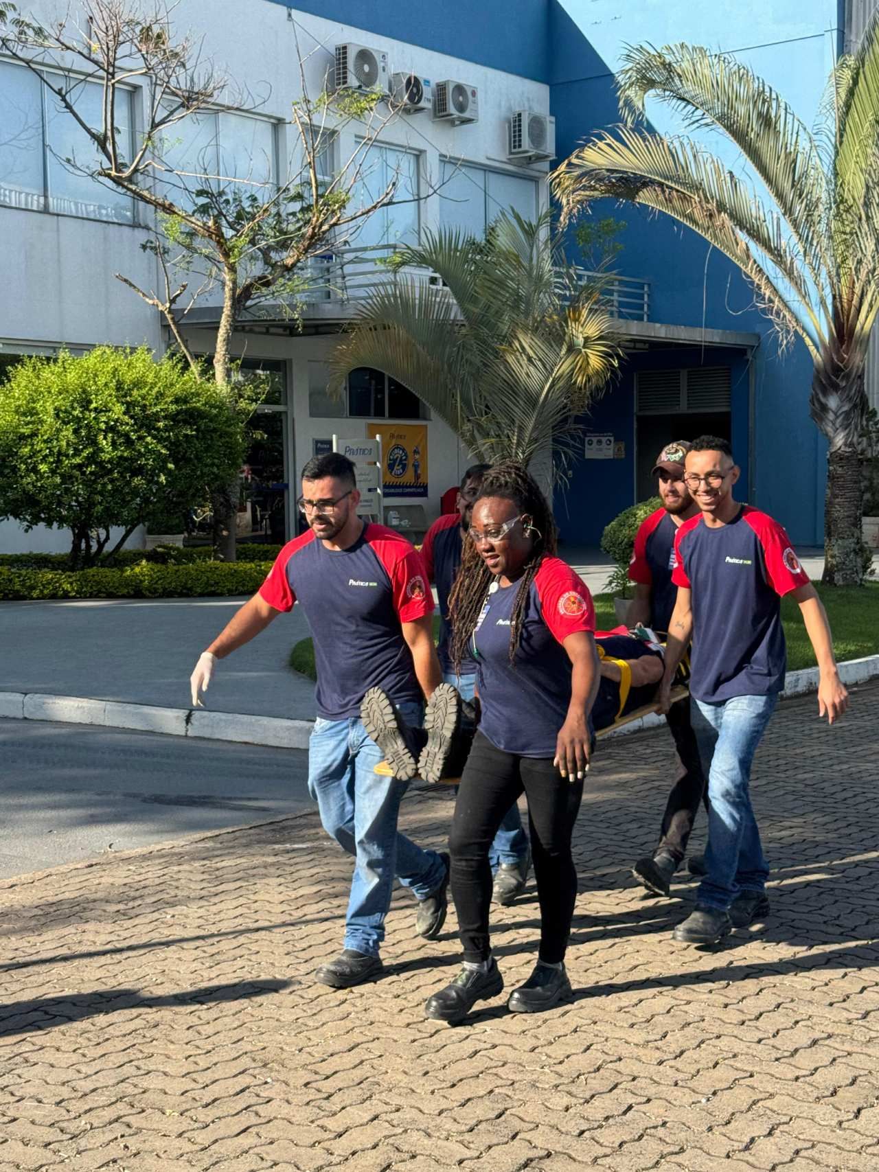 Um grupo de pessoas está carregando uma pessoa em uma maca.