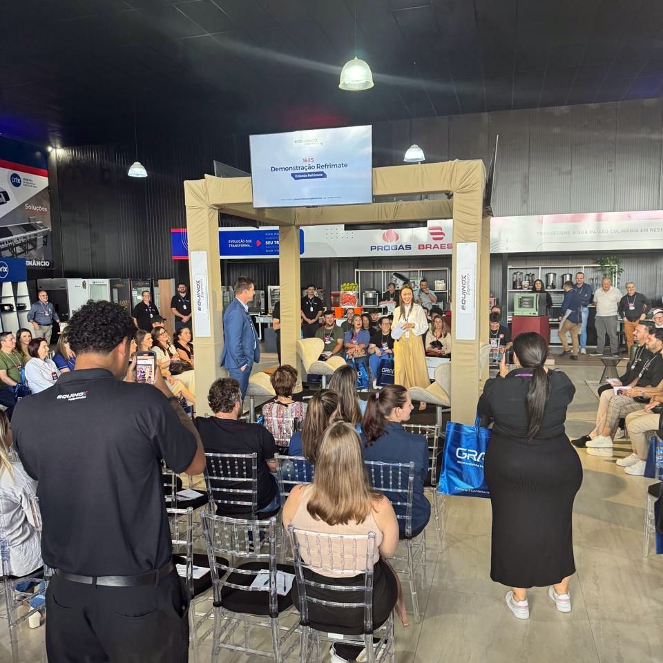 Um grupo de pessoas sentadas em cadeiras em uma sala com uma placa que diz 'United Airlines'