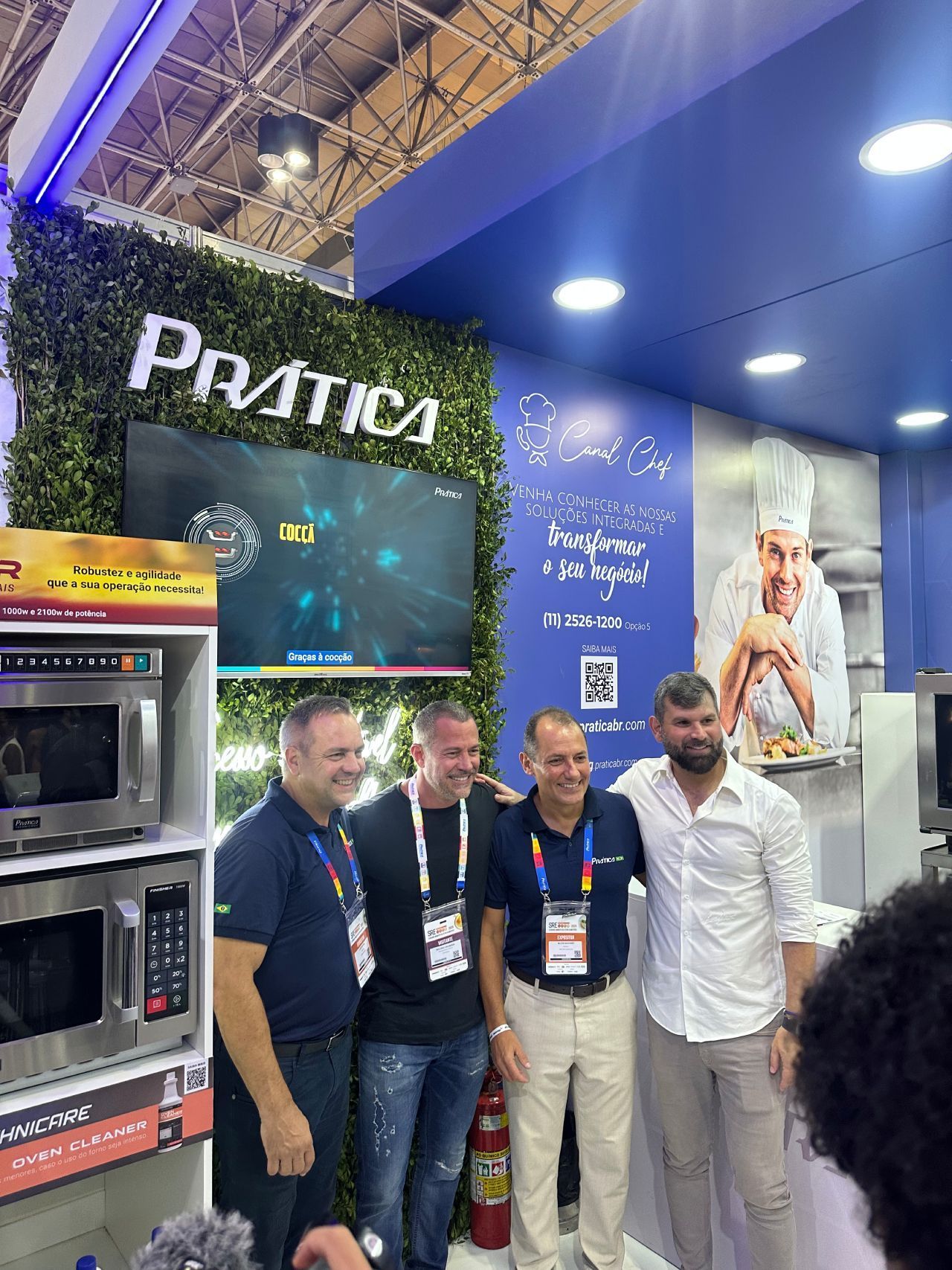 Um grupo de homens está posando para uma foto em um programa de culinária.