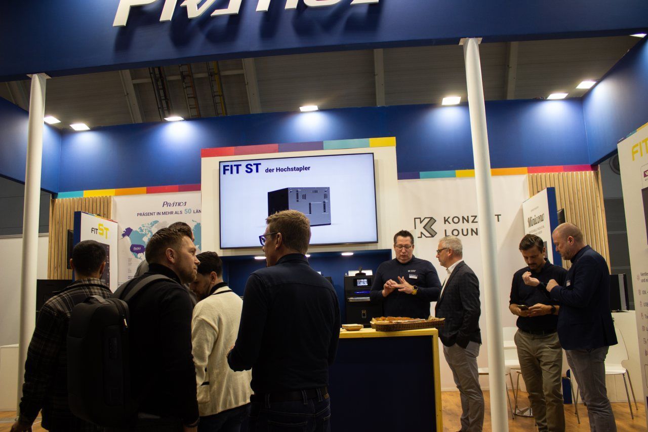 Um grupo de homens está parado em frente a uma placa que diz primeiro