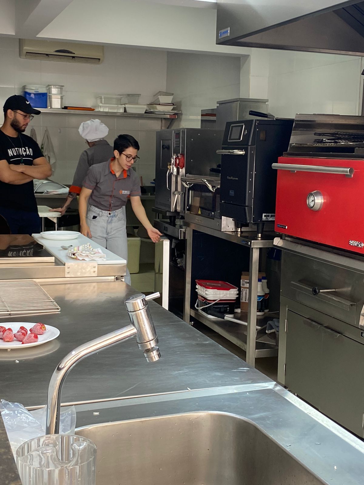 Uma cozinha com uma pia e um forno vermelho
