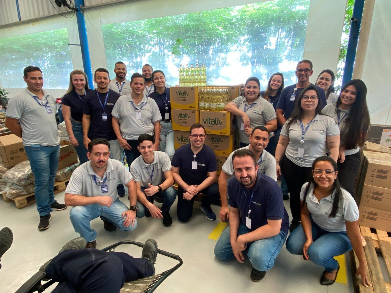 Um grupo de pessoas está posando para uma foto em um armazém.