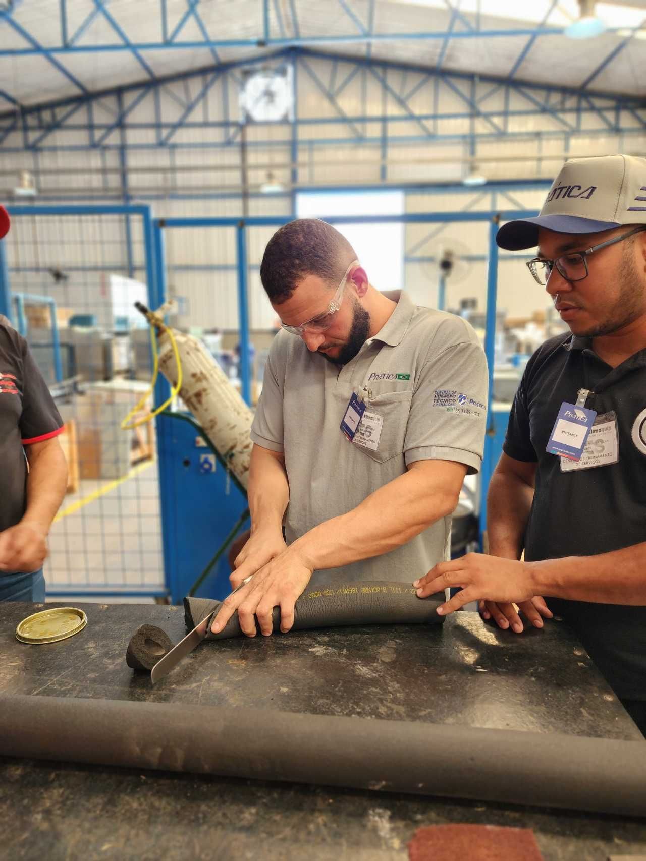 Um grupo de homens está trabalhando em uma peça de metal em uma fábrica.