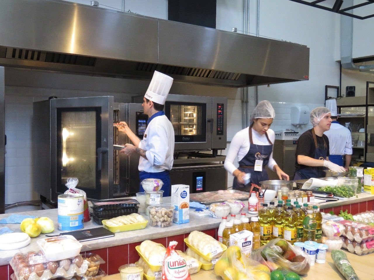 Um grupo de chefs está preparando comida em uma cozinha