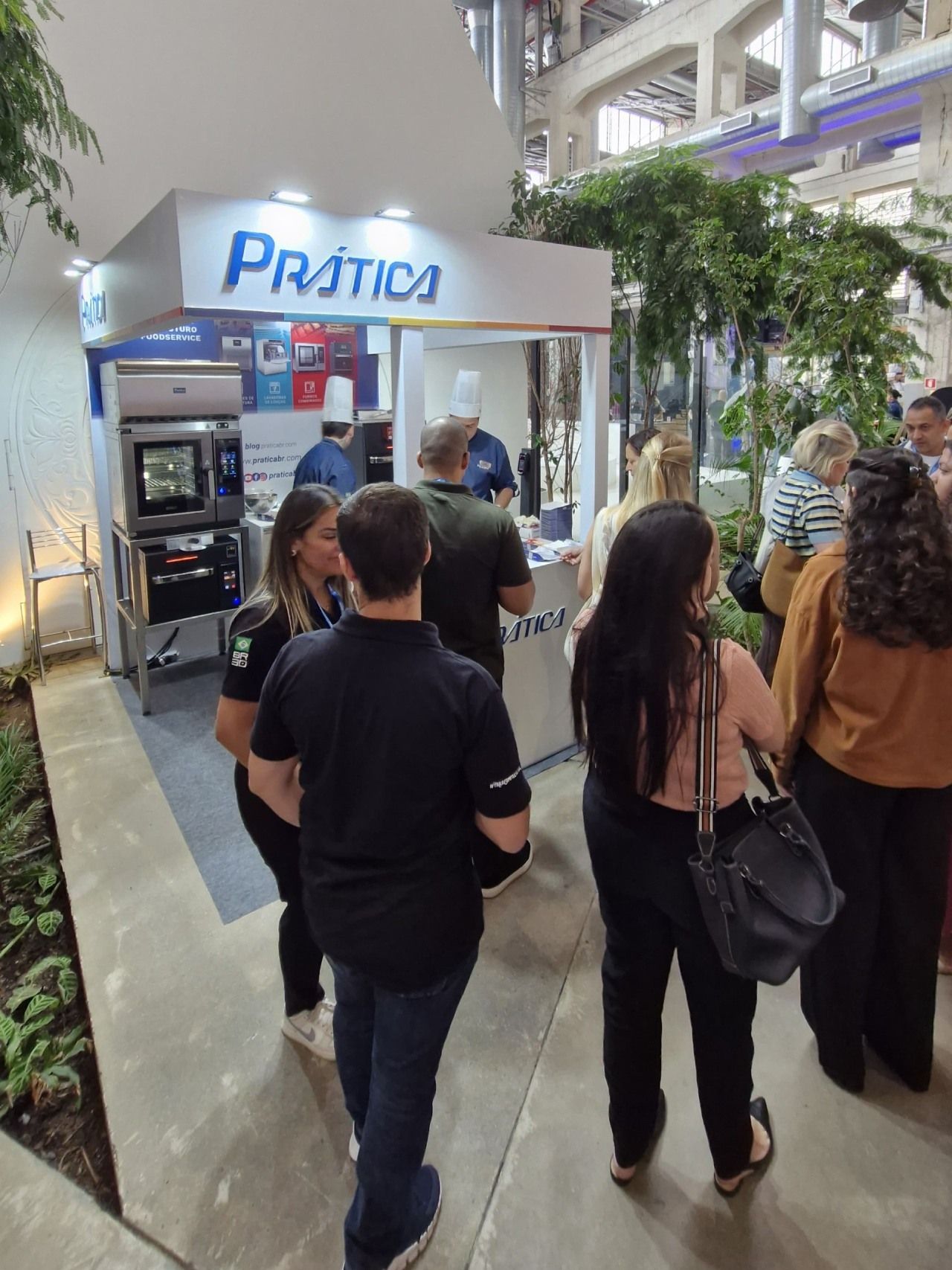 Um grupo de pessoas em pé em frente a um estande de prática