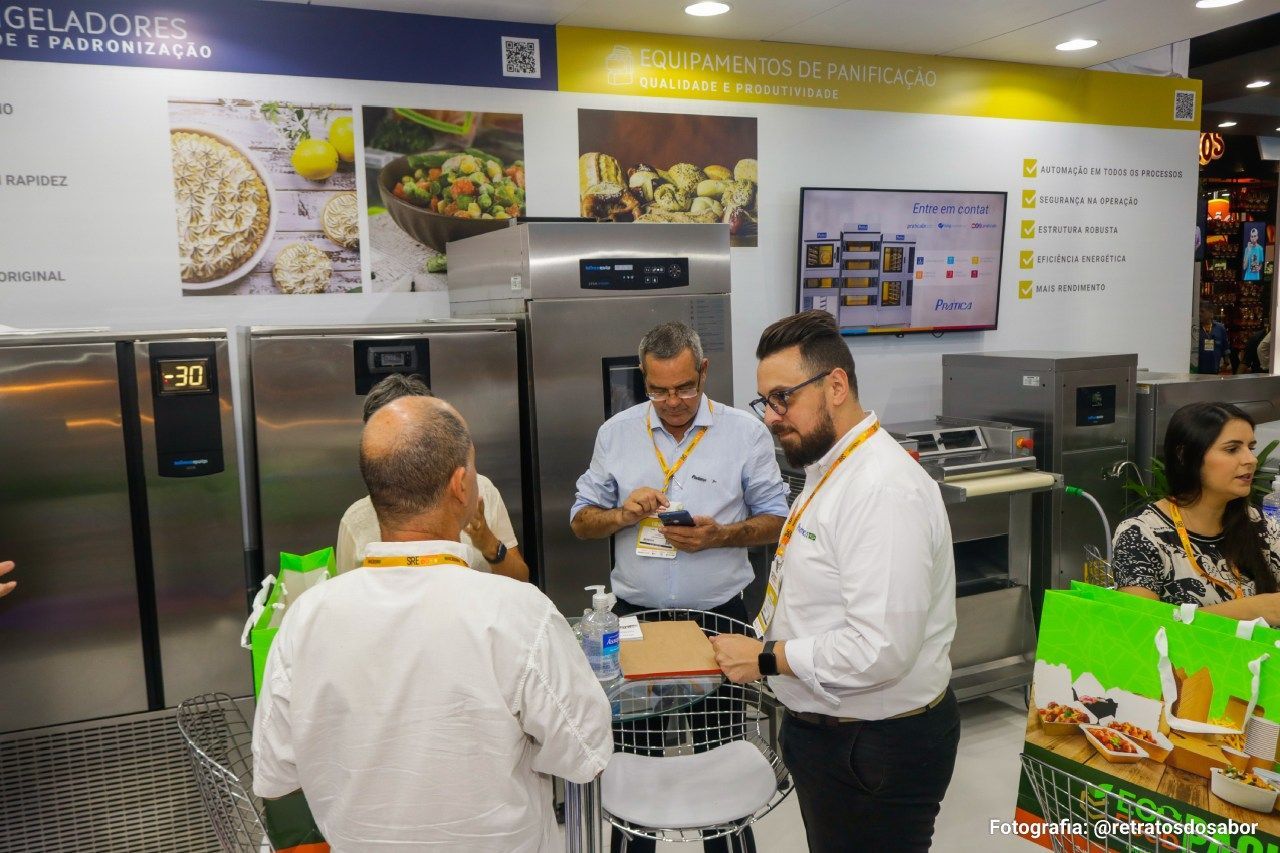 Um grupo de pessoas está em uma sala conversando entre si.
