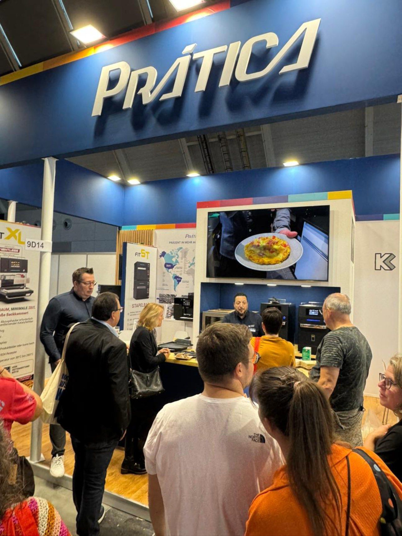 Um grupo de pessoas está em frente a um estande de prática.