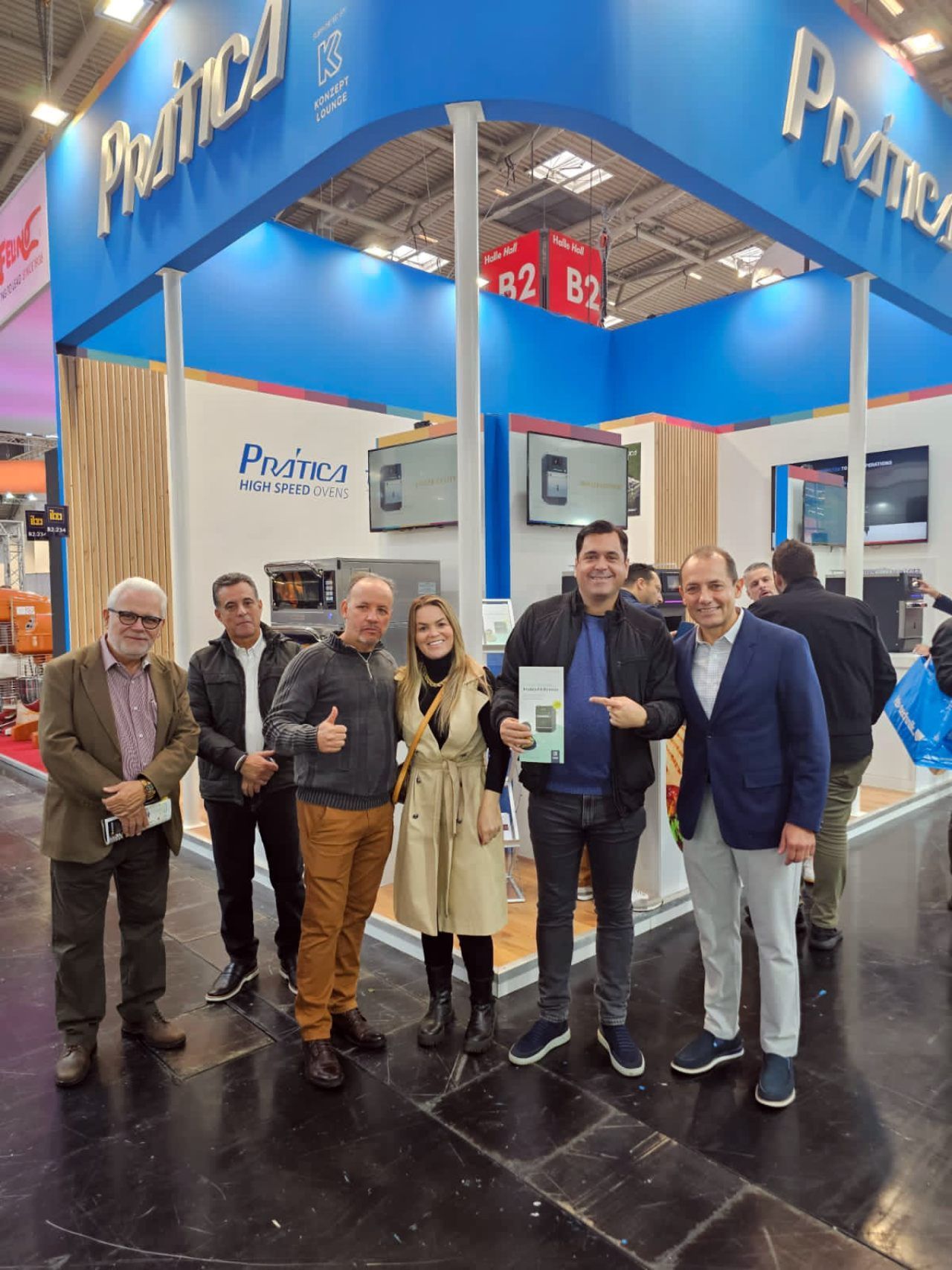 Um grupo de pessoas está posando para uma foto em frente a um estande da pacifica