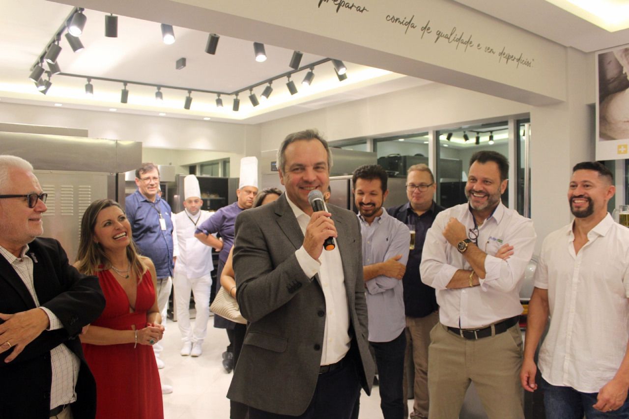 Um grupo de pessoas está em volta de um homem segurando um microfone.