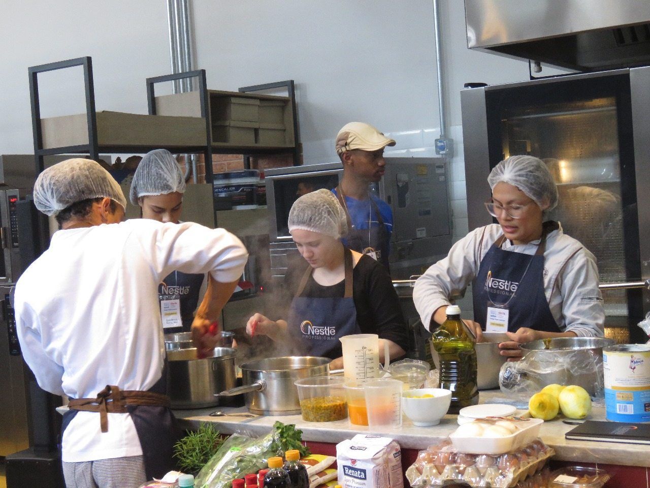 Um grupo de pessoas está preparando comida em uma cozinha