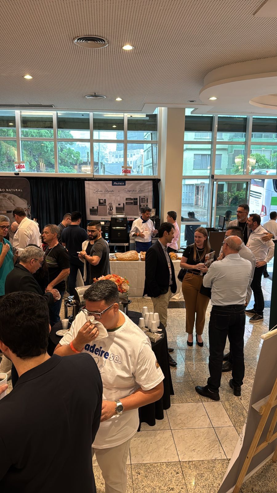 Um grupo de pessoas está em uma sala conversando entre si.