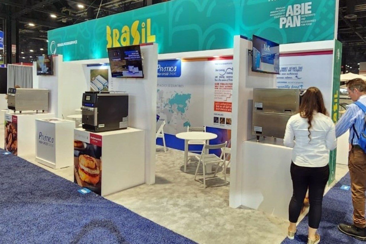 Uma mulher está parada em frente a uma barraca que diz brasil