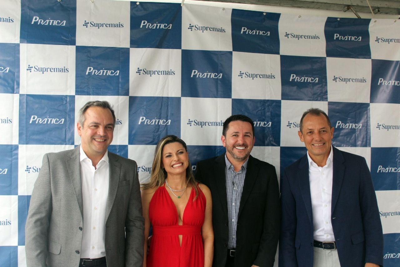 Um grupo de pessoas em frente a um cenário xadrez azul e branco