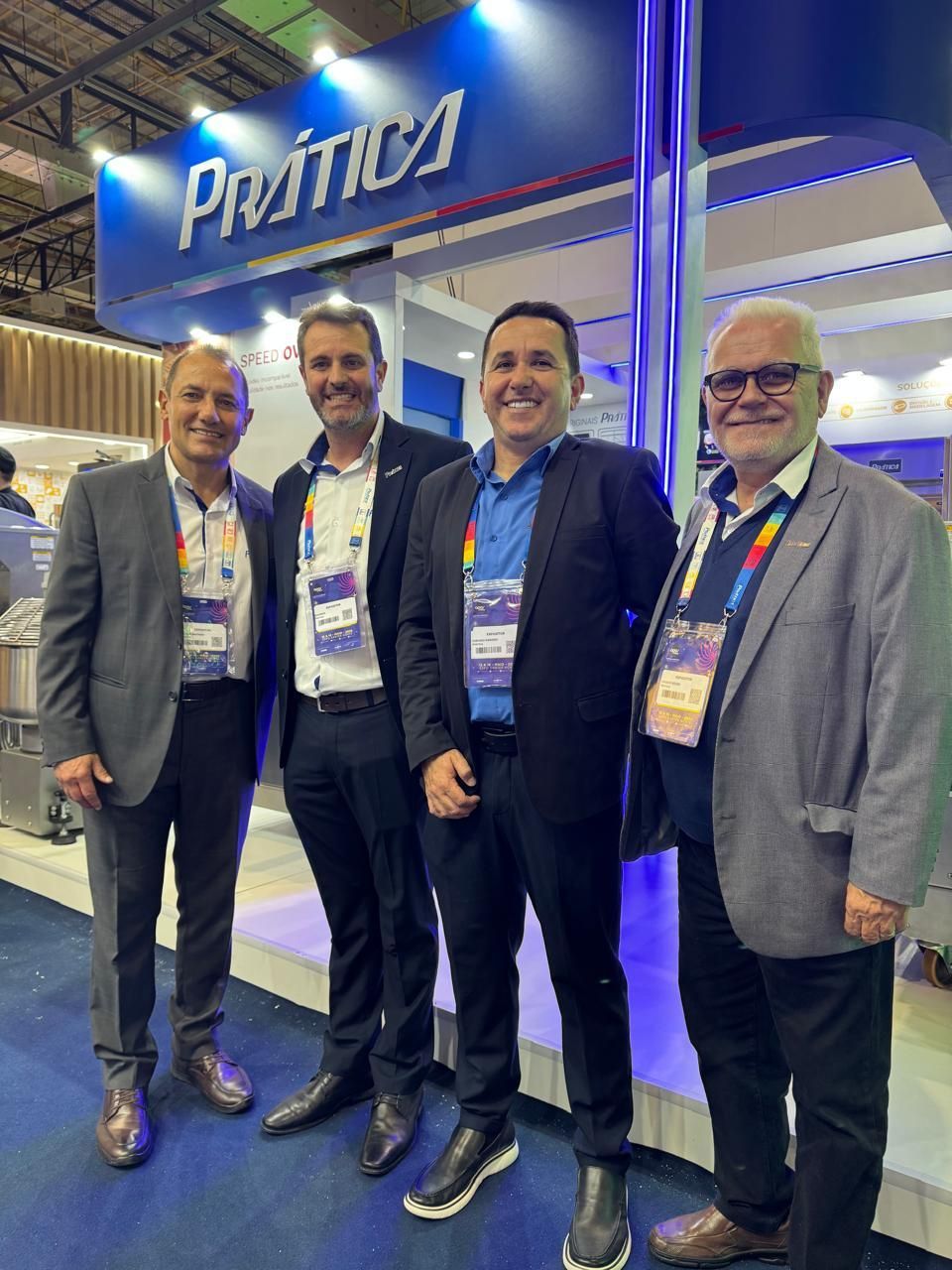 Um grupo de homens está posando para uma foto em frente a uma cabine.