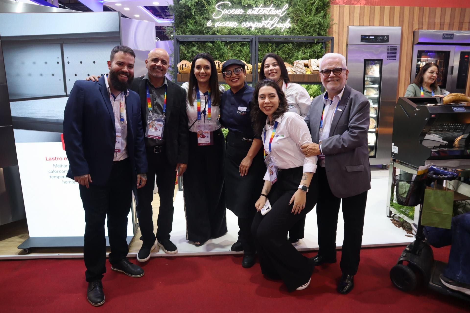 Um grupo de pessoas está posando para uma foto em uma convenção.