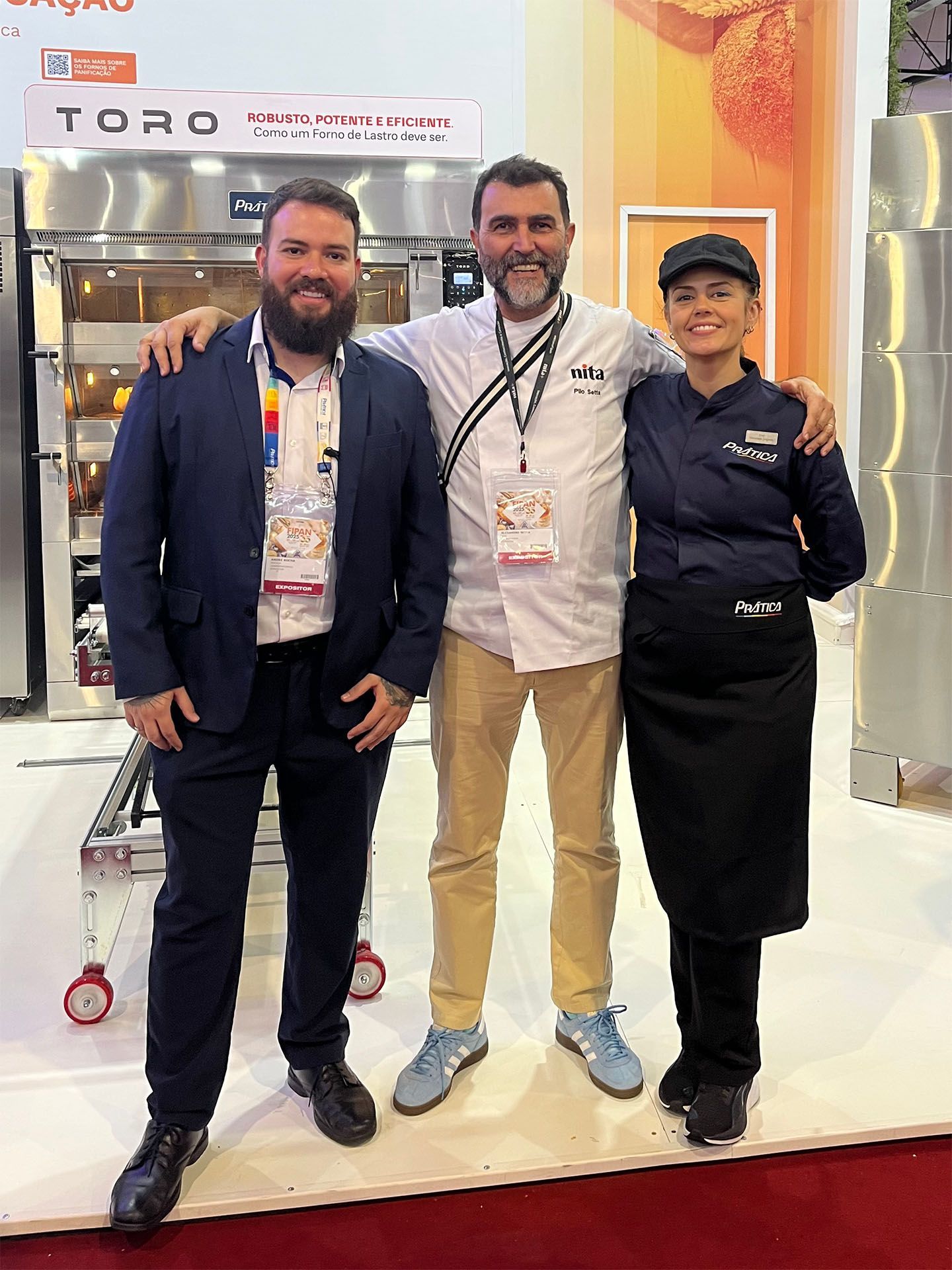 Três pessoas estão posando para uma foto em frente a uma placa que diz toro