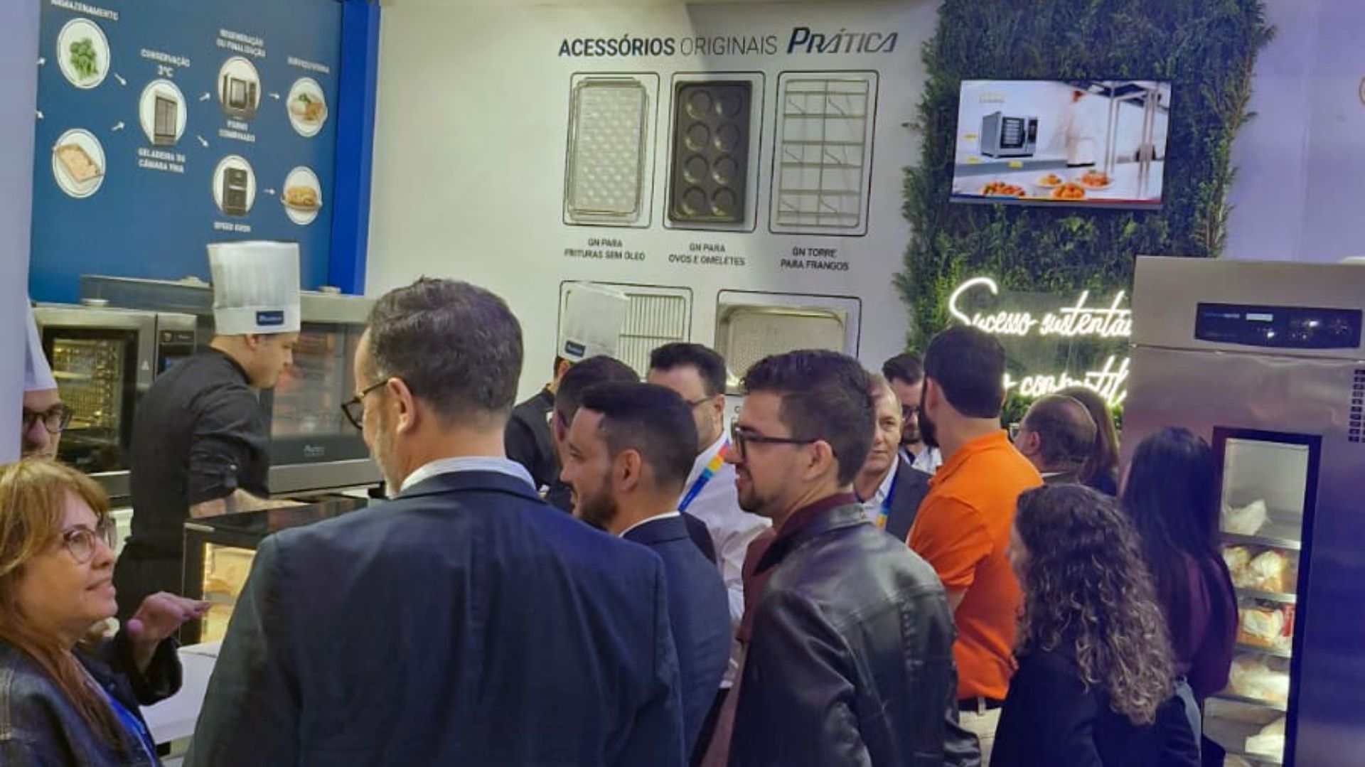 Um grupo de pessoas está em uma sala conversando entre si.